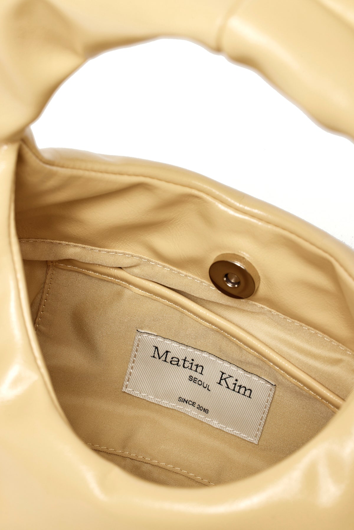 [matinkim] EMBOSSED LOGO LEATHER MINI TOTE BAG IN LIGHT YELLOW