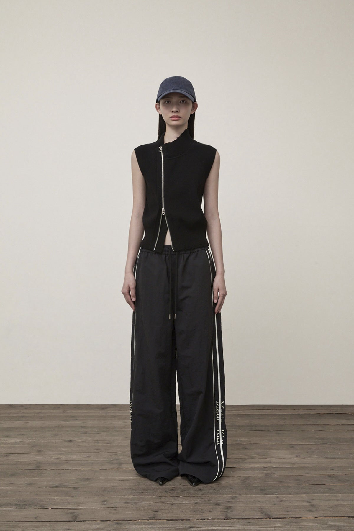 [matinkim] HIGH NECK LOGO KNIT ZIP UP VEST IN BLACK