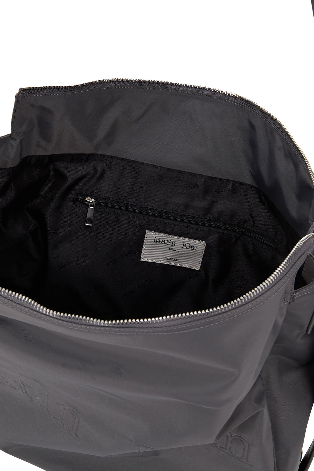 [matinkim] EMBOSSED LOGO FABRIC SHOULDER BAG IN CHARCOAL