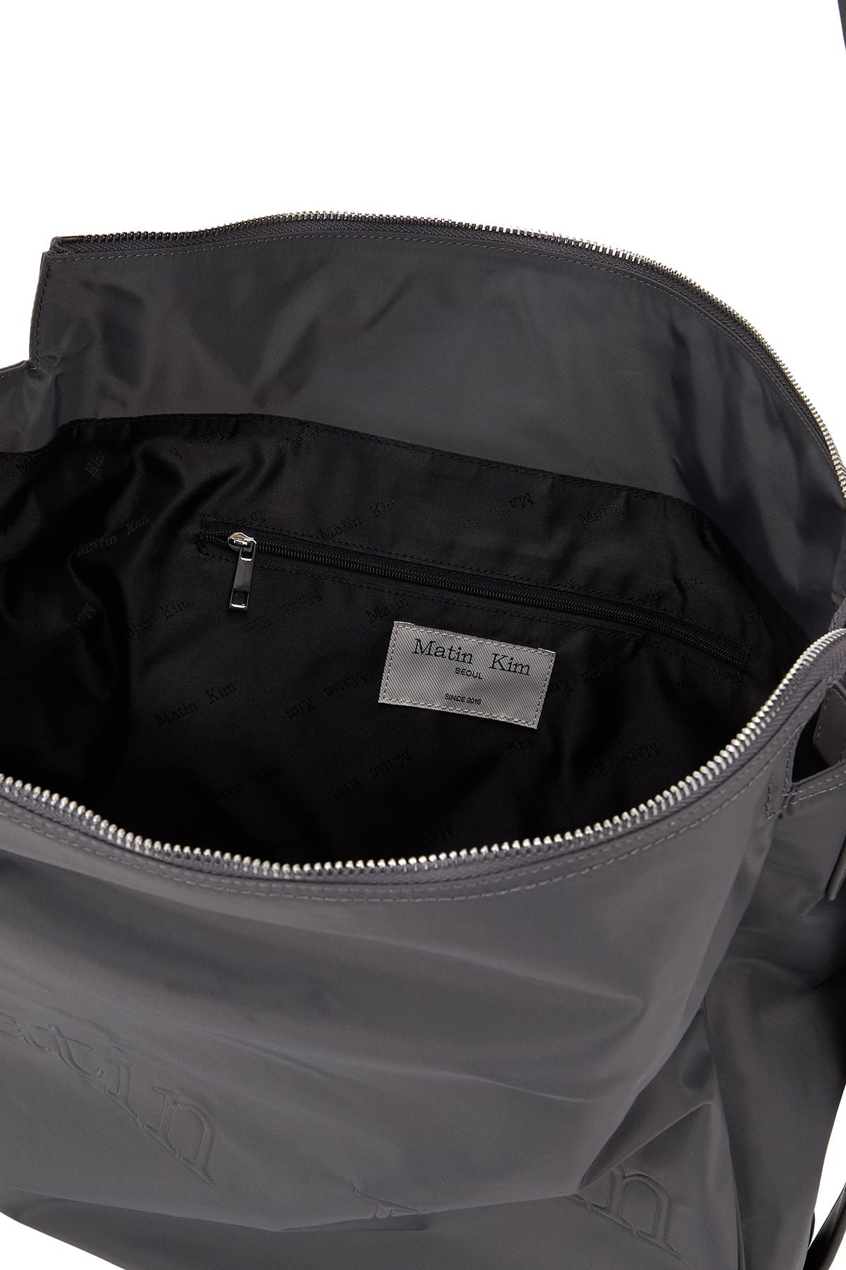 [matinkim] EMBOSSED LOGO FABRIC SHOULDER BAG IN CHARCOAL