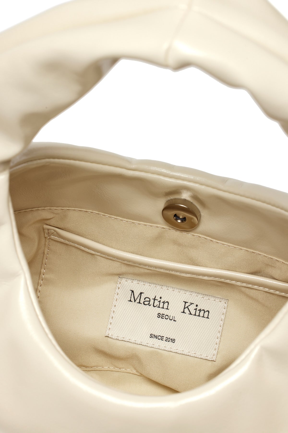 [matinkim] EMBOSSED LOGO LEATHER MINI TOTE BAG IN IVORY