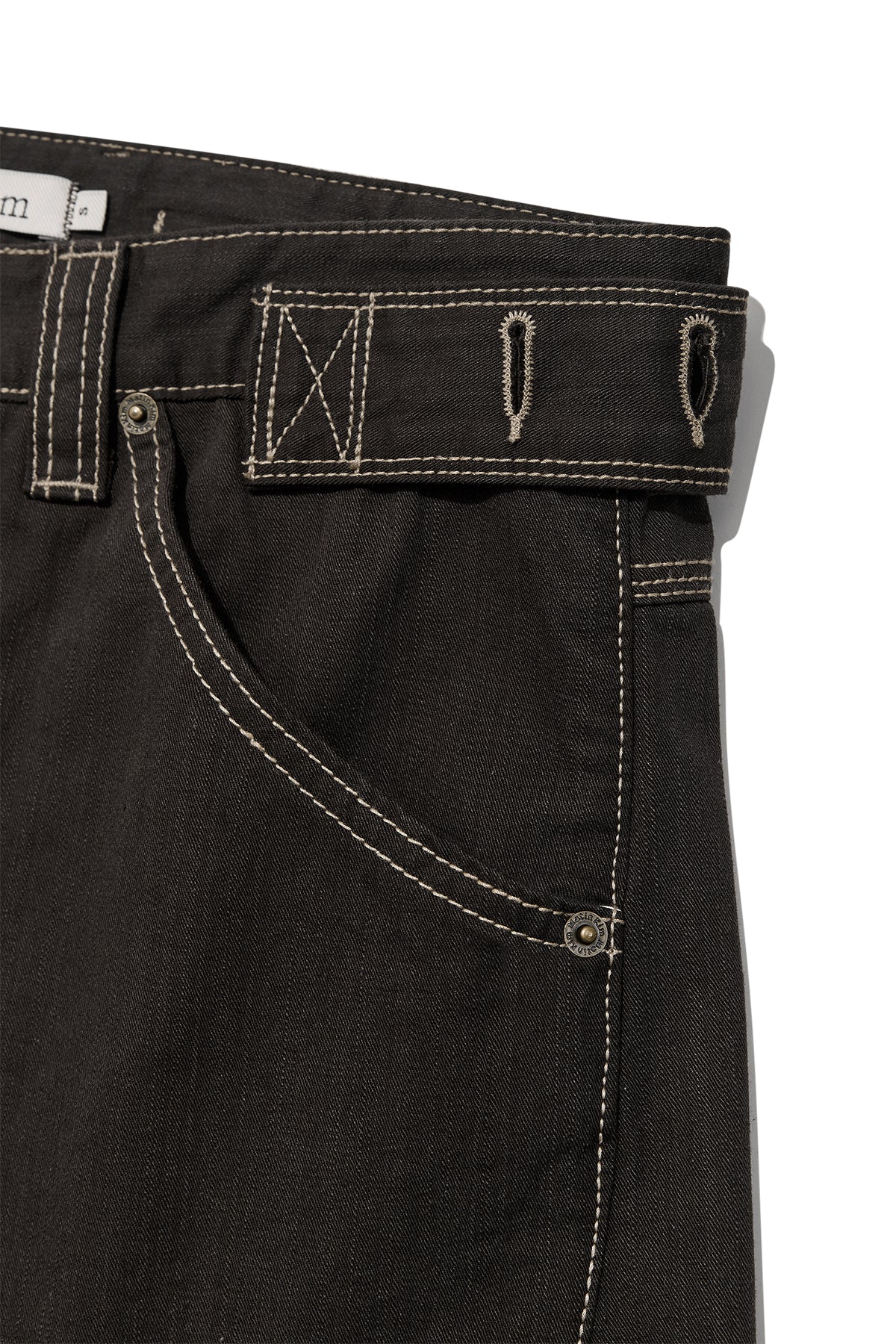 [matinkim] WAIST BUCKLE CURVED TWILL DENIM PANTS IN CHARCOAL