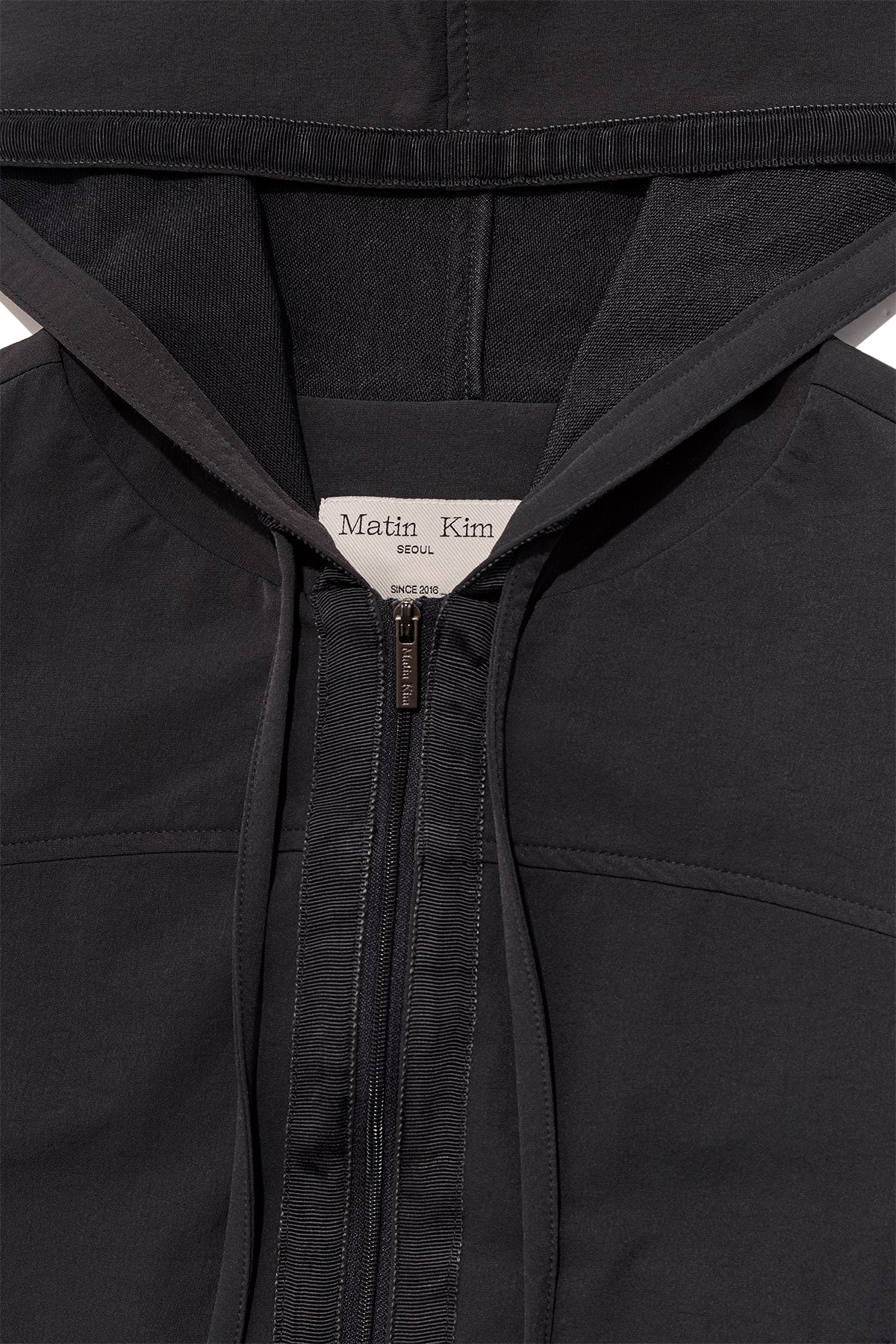 [matinkim] BACK LOGO LIGHT HOODY VEST IN CHARCOAL